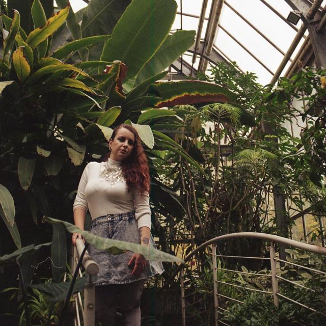Dívka s výrazným náhrdelníkem v botanické zahradě